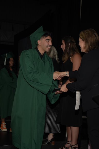 Estudiante estrechando la mano del director