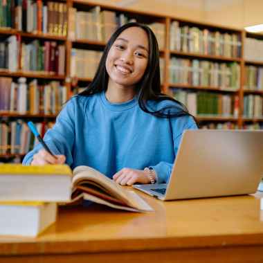 Chica sonriendo en la biblioteca.