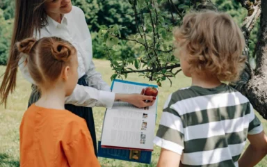 Un niño y una niña estudiando árboles